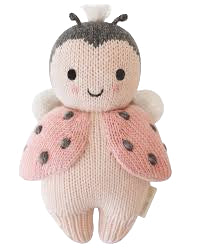 Knitted ladybug toy with pink wings and a smiling face on a white background