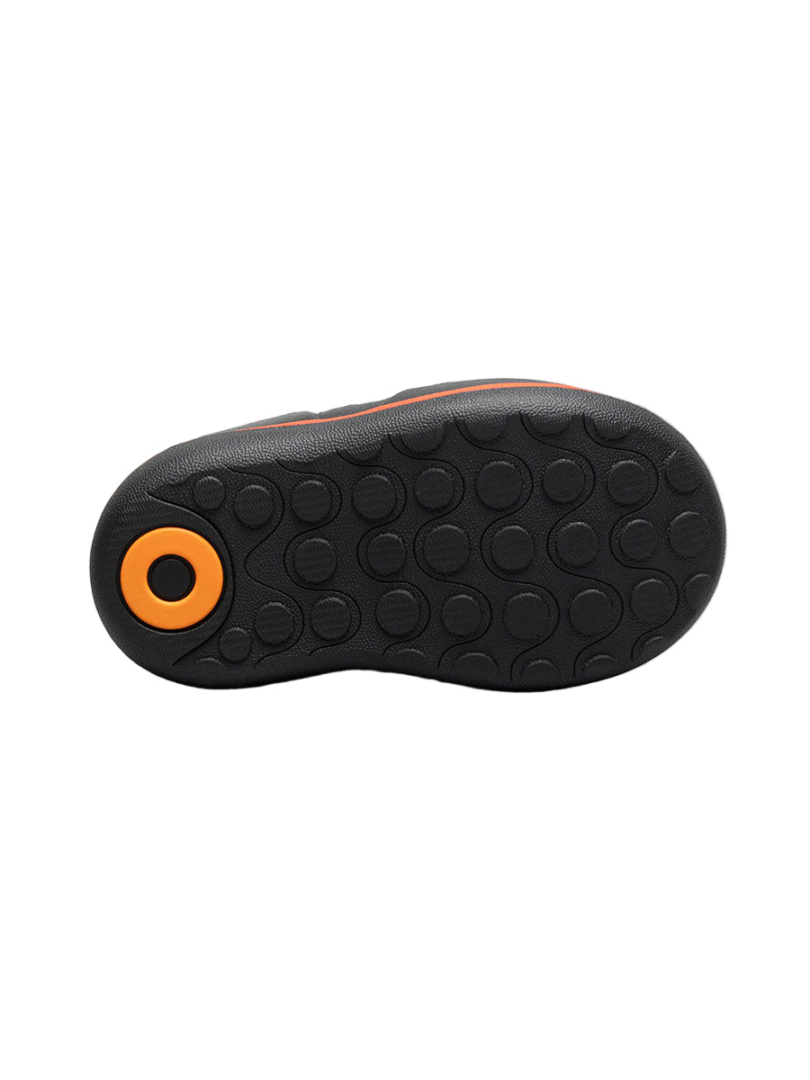 Black shoe sole with orange circular design on a white background
