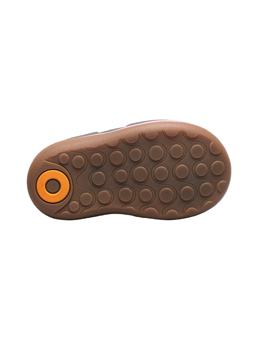 Brown shoe sole with orange circular design on a white background