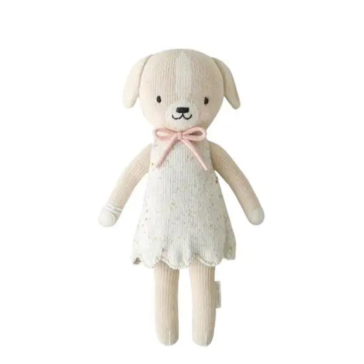 Stuffed dog toy with a white dress and pink bow on a white background