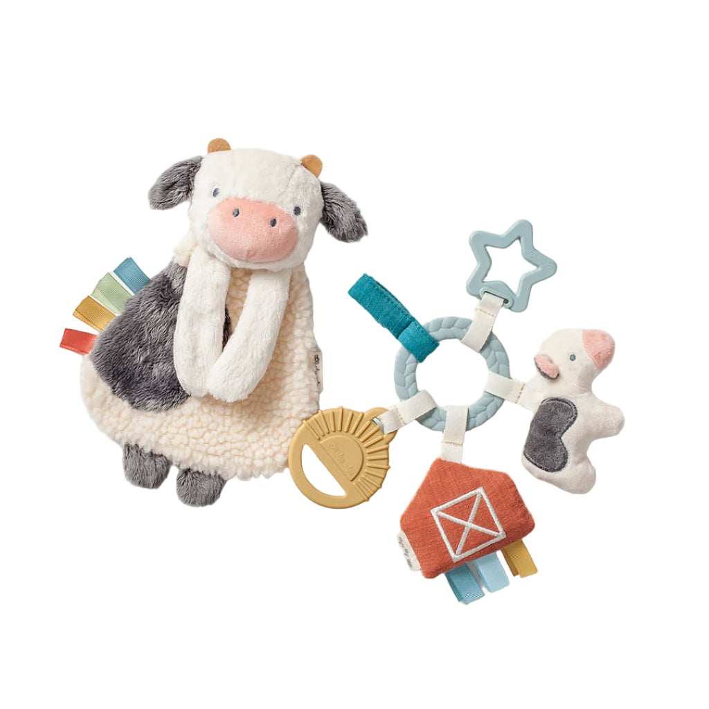 Children's toy with cow plushie and various textures on a light background